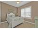 Comfortable bedroom features a window with plantation shutters, a ceiling fan, and a quaint bedside lamp at 12905 N Marsh Dr, Port Charlotte, FL 33953