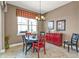 A dining room featuring a black round table, colorful chairs, and a bright red accent cabinet at 12905 N Marsh Dr, Port Charlotte, FL 33953