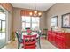 A dining room featuring a black round table, colorful chairs, and a bright red accent cabinet at 12905 N Marsh Dr, Port Charlotte, FL 33953