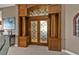 Elegant entrance with a frosted glass door and trimmed columns, enhancing the home's architectural interest at 12905 N Marsh Dr, Port Charlotte, FL 33953