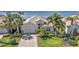 Elegant home with a well-manicured lawn, lush landscaping, and water views in a serene setting at 12905 N Marsh Dr, Port Charlotte, FL 33953