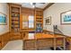 Charming office features custom built-in shelving, a ceiling fan, and a large desk with storage for optimal organization at 12905 N Marsh Dr, Port Charlotte, FL 33953