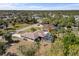 A view of a house and fenced-in pool with a screened enclosure and tropical trees at 1386 N Lavina St, North Port, FL 34286