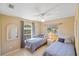 Bright bedroom with two twin beds, a ceiling fan, and ample natural light is airy and inviting at 1386 N Lavina St, North Port, FL 34286