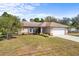 Charming single-story home featuring a well-maintained lawn, neutral color palette, and an attached two-car garage at 1386 N Lavina St, North Port, FL 34286