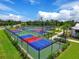 Overhead view of colorful pickleball courts with nets and fencing, surrounded by green landscaping at 14091 Heritage Landing Blvd # 123, Punta Gorda, FL 33955