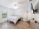 A bright bedroom featuring tile floors, a ceiling fan, and a large window with bright natural light at 14325 Mcfarland Ave, Port Charlotte, FL 33981