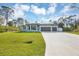 Beautiful single-story home with three-car garage, well-manicured lawn and blue-painted exterior at 14325 Mcfarland Ave, Port Charlotte, FL 33981