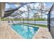 A beautiful screened-in pool with brick pavers and outdoor seating offers the perfect spot for relaxation and entertainment at 14325 Mcfarland Ave, Port Charlotte, FL 33981