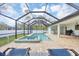 Enclosed pool and spa area with brick patio and a view of the backyard and surrounding trees at 14325 Mcfarland Ave, Port Charlotte, FL 33981