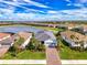 Aerial view of a beautiful single-story home that overlooks a scenic pond in a well-maintained community at 15033 Spanish Point Dr, Port Charlotte, FL 33981