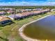 Beautiful aerial view of lakeside homes showcasing screened-in patios and well-manicured lawns at 15033 Spanish Point Dr, Port Charlotte, FL 33981