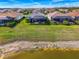 Backyards overlooking a serene lake featuring screened enclosures and manicured green lawns at 15033 Spanish Point Dr, Port Charlotte, FL 33981