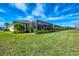 Expansive backyard featuring lush green grass, a screened-in lanai, and meticulous landscaping at 15033 Spanish Point Dr, Port Charlotte, FL 33981