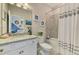 Well-lit bathroom with a granite countertop vanity, tiled shower, and decorative accents at 15033 Spanish Point Dr, Port Charlotte, FL 33981
