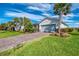 Beautiful home with a brick driveway, meticulously maintained lawn, and lush tropical landscaping at 15033 Spanish Point Dr, Port Charlotte, FL 33981
