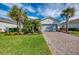 Charming single-story home featuring a brick driveway, well-kept lawn and beautiful tropical landscaping at 15033 Spanish Point Dr, Port Charlotte, FL 33981