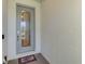 Elegant front door with decorative glass, framed by fresh paint and a welcoming mat at 15033 Spanish Point Dr, Port Charlotte, FL 33981