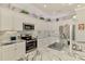 Well-lit kitchen with stainless steel appliances, granite countertops, and custom backsplash at 15033 Spanish Point Dr, Port Charlotte, FL 33981
