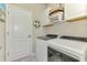 Efficient laundry room equipped with modern washer and dryer, storage cabinets, and convenient access at 15033 Spanish Point Dr, Port Charlotte, FL 33981