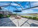 Screened-in patio with beautiful lake view, patio set with umbrella, and stunning blue skies at 15033 Spanish Point Dr, Port Charlotte, FL 33981