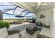 Relax on this screened lanai with comfortable seating and outdoor dining overlooking a tranquil water view at 15033 Spanish Point Dr, Port Charlotte, FL 33981