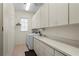 Bright and functional laundry room with washer, dryer, sink, and ample cabinet space at 1921 Pebble Beach Ct, Venice, FL 34293