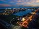 Beautiful aerial shot of waterfront homes at twilight, with city lights in the distance at 197 Colony Point Dr, Punta Gorda, FL 33950