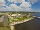 Aerial view of a coastal city with palm-lined streets, a bridge, and waterfront buildings under a partly cloudy sky at 197 Colony Point Dr, Punta Gorda, FL 33950