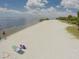 Expansive beach view showcasing the shoreline and calm waters on a sunny day at 197 Colony Point Dr, Punta Gorda, FL 33950
