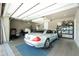 View of garage featuring a silver car parked on a blue mat, and multiple storage shelves on the right at 197 Colony Point Dr, Punta Gorda, FL 33950