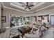 Open-concept living room featuring a tray ceiling, comfortable seating, and seamless transition to the kitchen and outdoor spaces at 197 Colony Point Dr, Punta Gorda, FL 33950