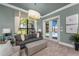 Comfortable living room features a plush sofa, storage ottoman, and serene views of the pool and backyard at 197 Colony Point Dr, Punta Gorda, FL 33950