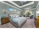 Spacious bedroom with neutral tones, tray ceiling, chandelier, and a seating area with lots of natural light at 197 Colony Point Dr, Punta Gorda, FL 33950