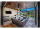 A covered outdoor kitchen with stainless steel grill and view of the pool and lanai seating at 197 Colony Point Dr, Punta Gorda, FL 33950