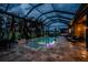 Inviting screened pool area featuring ambient lighting, comfortable seating, and tranquil water views at twilight at 197 Colony Point Dr, Punta Gorda, FL 33950