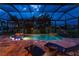 Inviting screened pool area featuring ambient lighting, comfortable seating, and tranquil water views at twilight at 197 Colony Point Dr, Punta Gorda, FL 33950