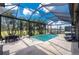 Beautiful screened pool and lanai area with outdoor seating, lush landscaping, and serene water views at 197 Colony Point Dr, Punta Gorda, FL 33950