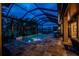 Inviting screened pool area featuring ambient lighting, comfortable seating, and tranquil water views at twilight at 197 Colony Point Dr, Punta Gorda, FL 33950