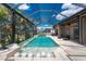 Beautiful screened pool and lanai area with outdoor seating, lush landscaping, and serene water views at 197 Colony Point Dr, Punta Gorda, FL 33950