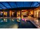 Outdoor pool and patio with seating area and outdoor kitchen at twilight at 197 Colony Point Dr, Punta Gorda, FL 33950
