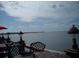 Serene waterfront view with outdoor seating, featuring decorative lamps and a distant cityscape in the background at 197 Colony Point Dr, Punta Gorda, FL 33950