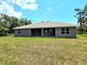 A spacious backyard features a covered patio on a modern home with large windows, perfect for enjoying the outdoors at 2201 Como St, Port Charlotte, FL 33948