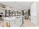 A modern kitchen island with a sink, dishwasher, and pendant lights is open to a living room at 2220 Darley Oak Way, North Port, FL 34289