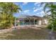 Backyard of home with enclosed pool area and tropical landscaping at 23488 Almond Ave, Port Charlotte, FL 33954