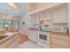 Bright kitchen with white appliances, tile backsplash, and white tile flooring is adjacent to the dining area at 23488 Almond Ave, Port Charlotte, FL 33954
