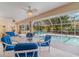 Enclosed lanai with dining set, ceiling fans and view of pool and landscaping at 23488 Almond Ave, Port Charlotte, FL 33954