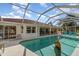 Backyard view of pool with full enclosure and large pool deck at 23488 Almond Ave, Port Charlotte, FL 33954