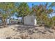 Backyard featuring a storage shed, mature trees, and a gravel ground cover at 2440 Ednor St, Port Charlotte, FL 33952