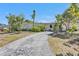 Charming single-story home with a cracked driveway and lush, mature landscaping at 2440 Ednor St, Port Charlotte, FL 33952